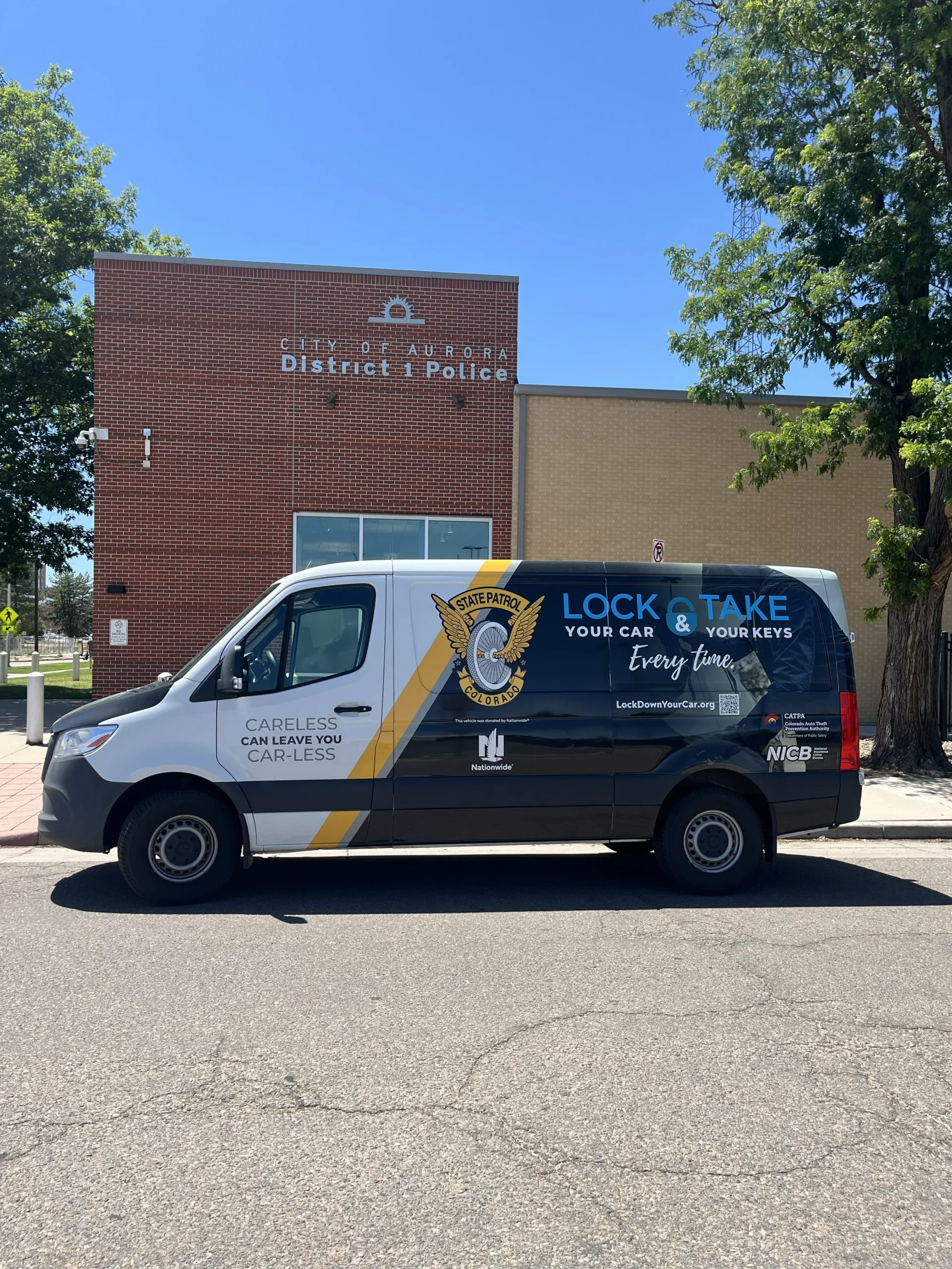 A van in front of a building promoting auto theft prevention